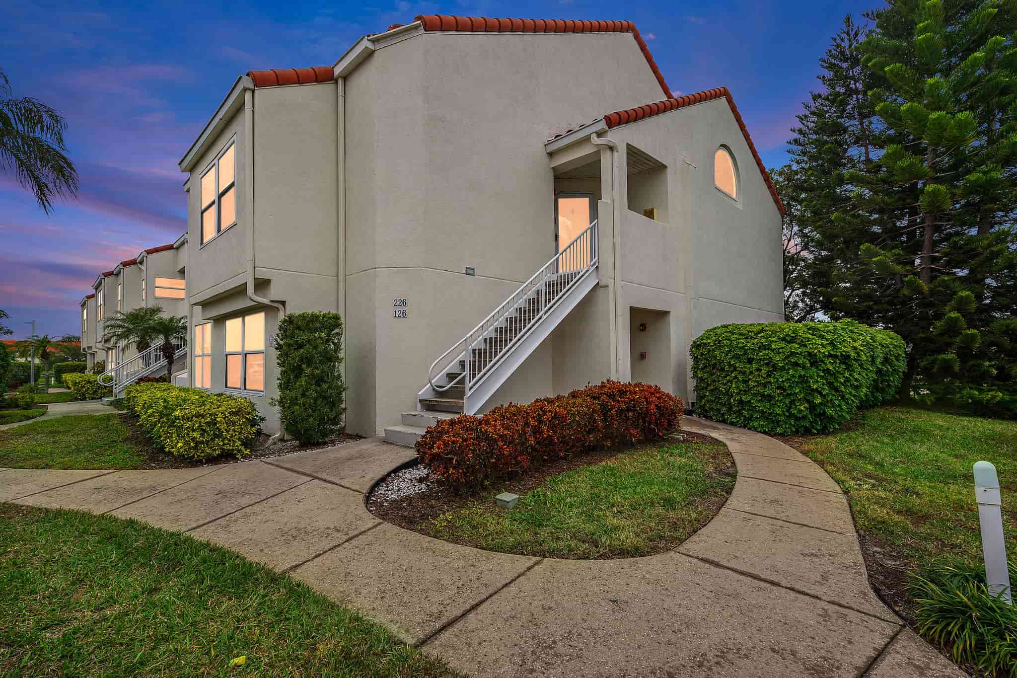A stucco apartment building with a white staircase.