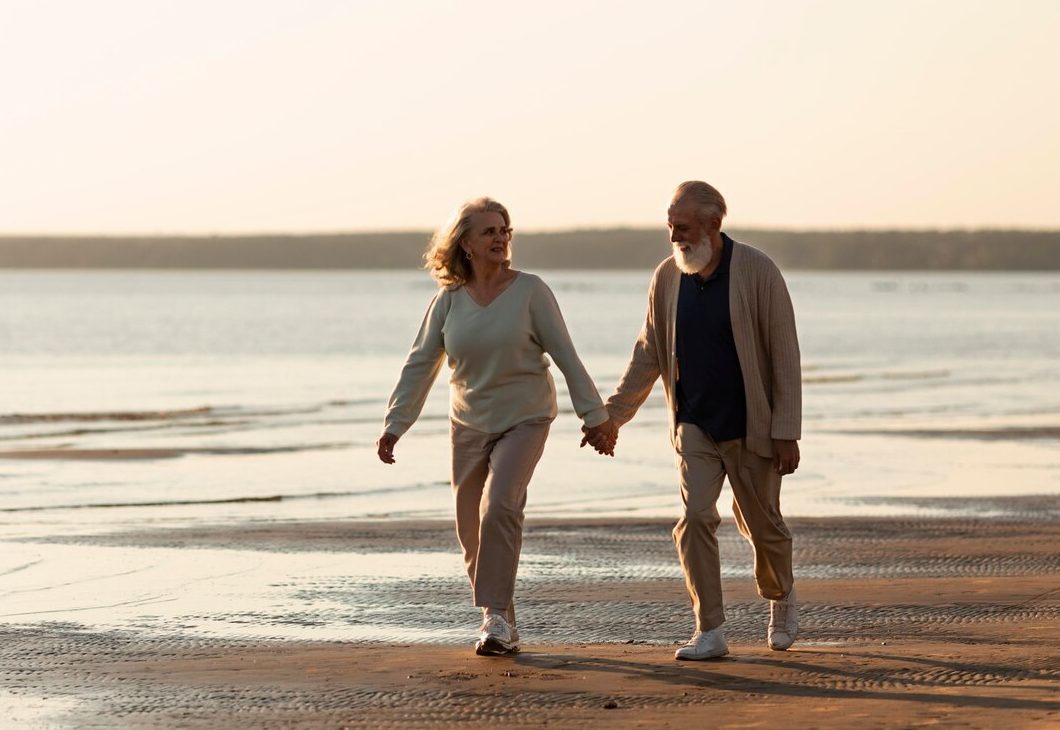 old couple walking on the beach