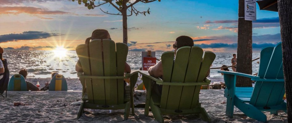 Couple relaxing on the beach under a beautiful sunset