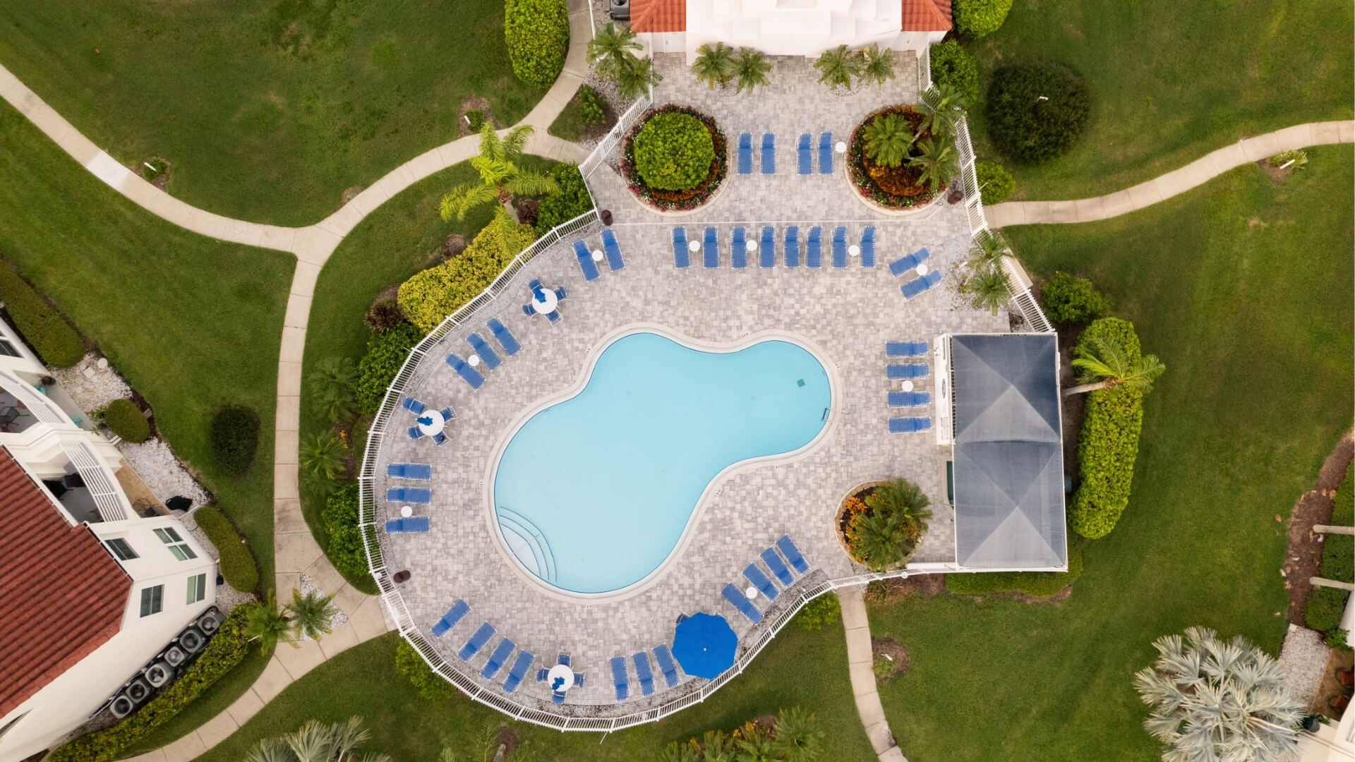 outdoor swimming pool centered on a paved patio