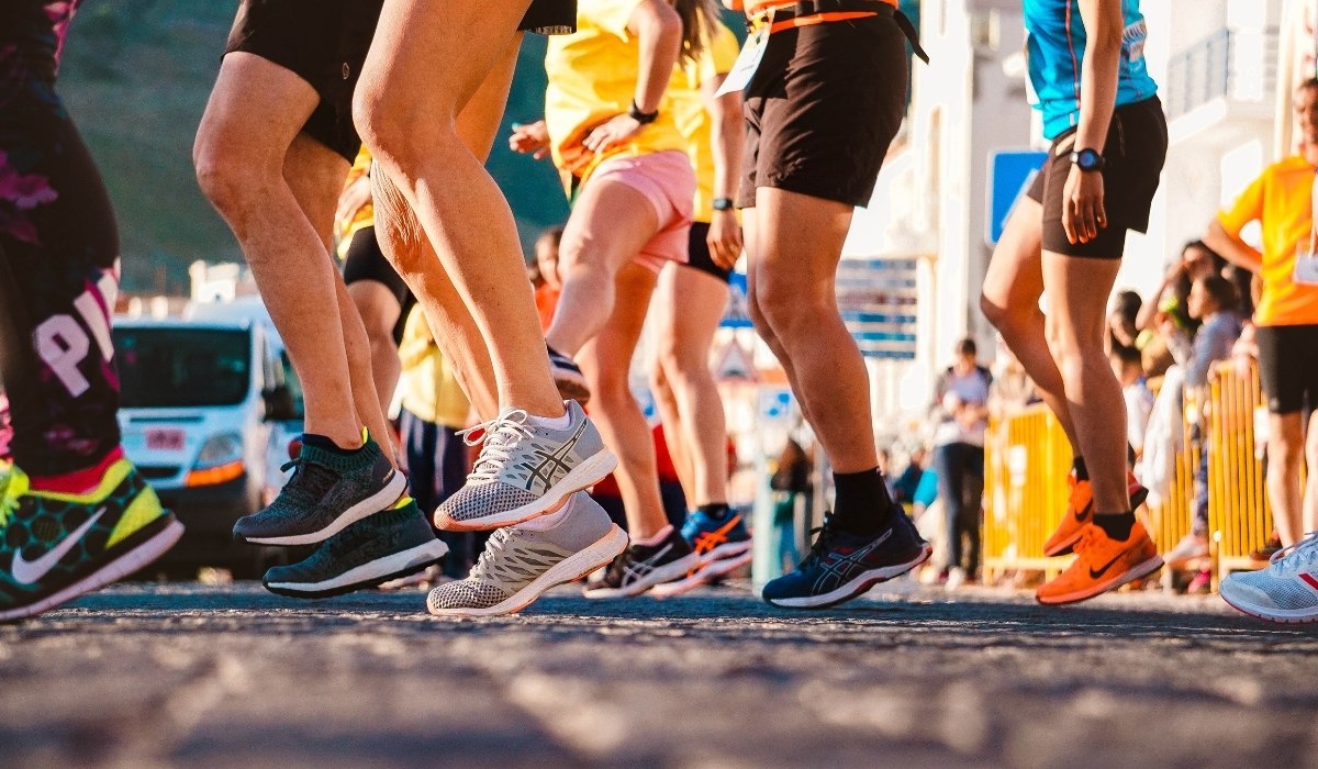 close-up shot captures the lower legs and feet of a group of runners